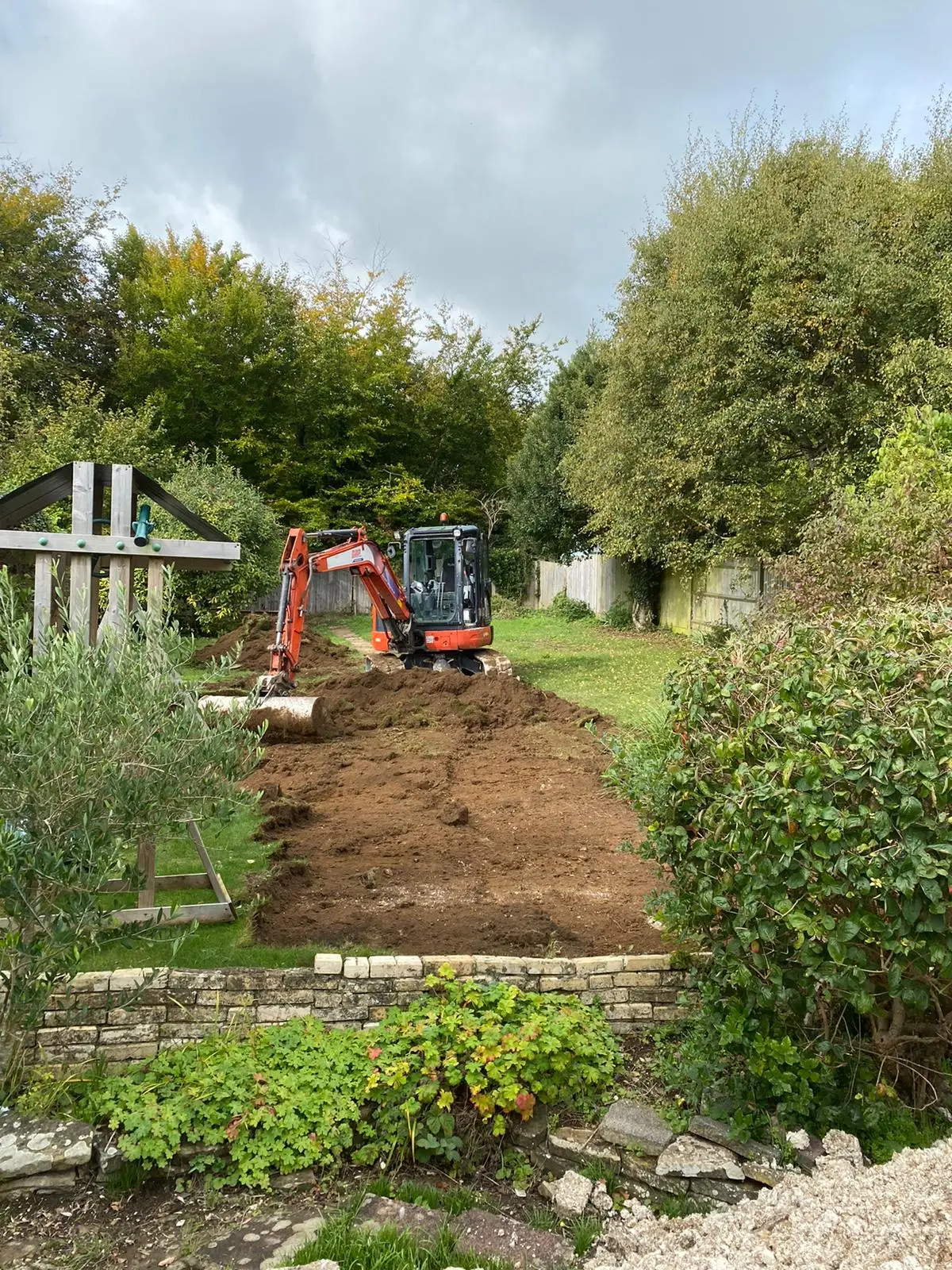 A digger at work on the sloping garden