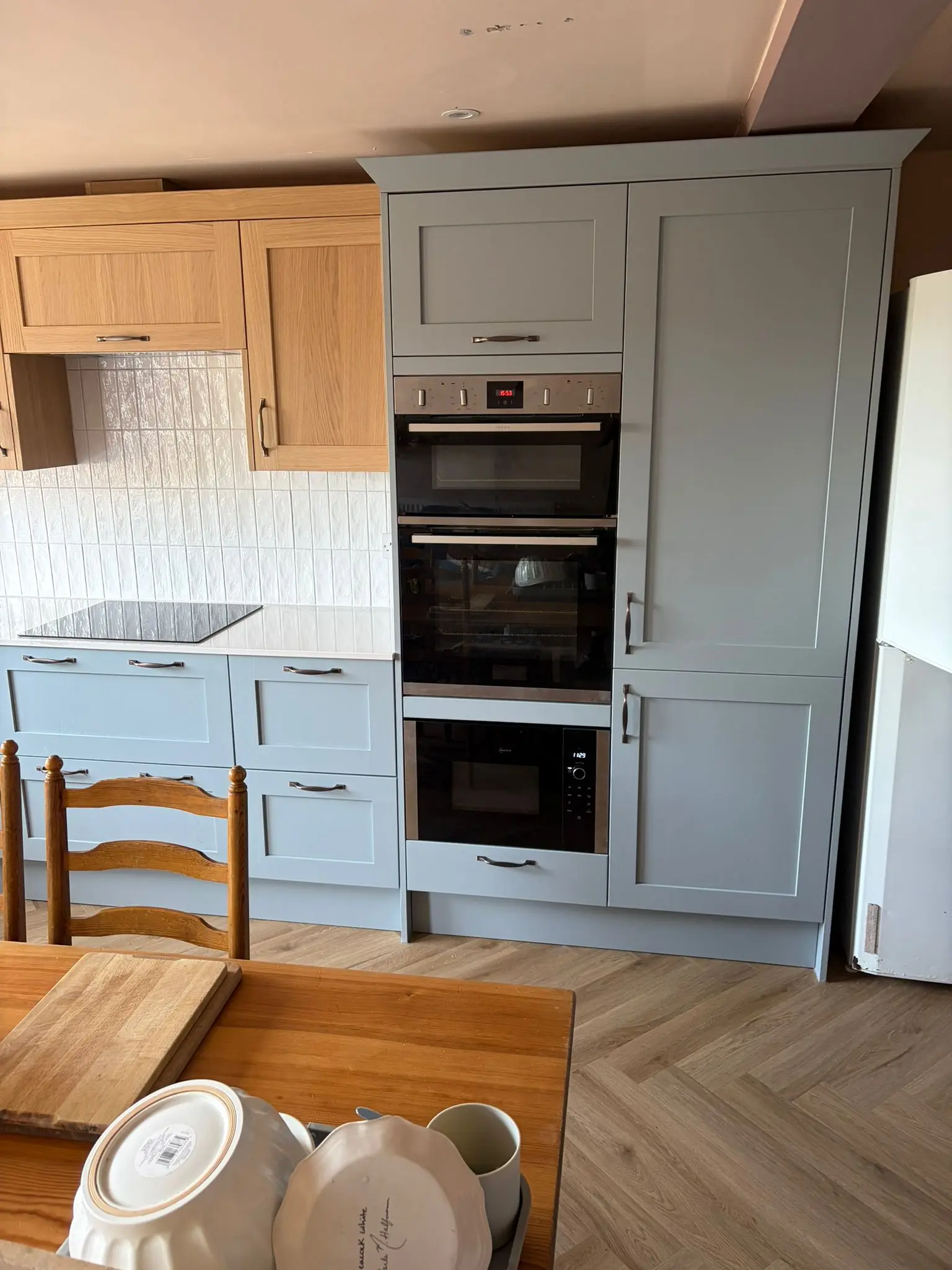 Tall blue-grey units housing a double oven and built-in microwave