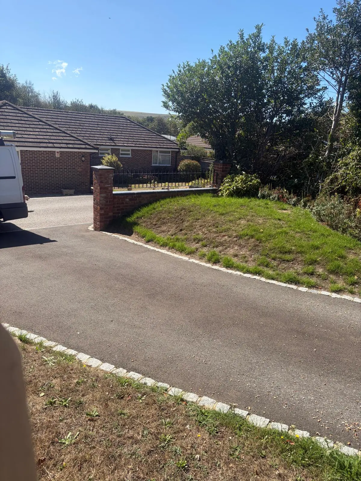 The curved driveway edged with granite setts, running past the new wall
